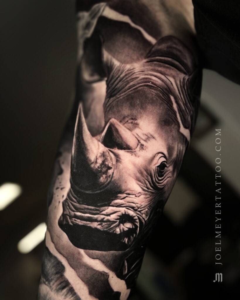 Nashorn Tier Porträt Realismus Tattoo erstellt von Joel Meyer, Tätowierer in Laval 53, Frankreich, in seinem privaten Tattoo Studio.